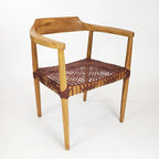 Poltrona da salotto con braccioli in legno di teak e seduta in pelle intrecciata